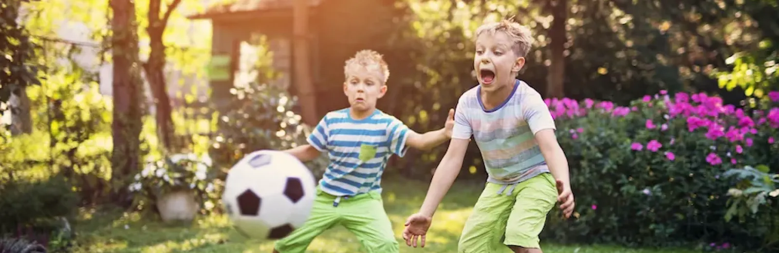 Kids playing soccer in a green yard