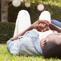 Couple outside lying in grass