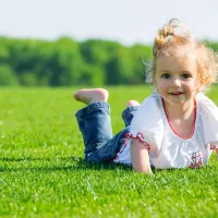 Happy kid outside enjoying green grass