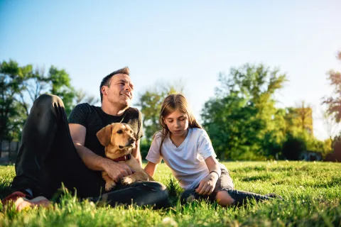 Family spending time sitting in green, healthy grass