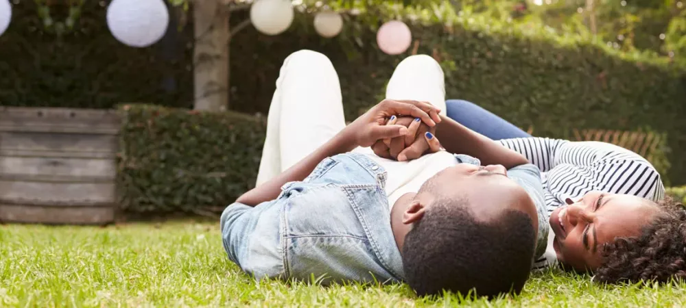 Couple outside lying in grass