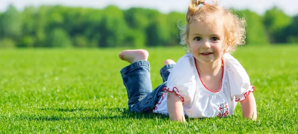 Happy kid outside enjoying green grass